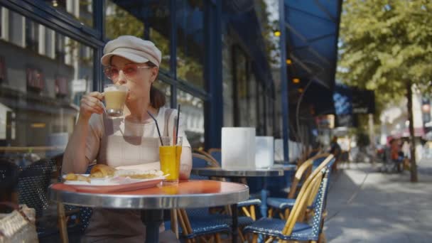Ευτυχισμένο Κορίτσι Τρώει Πρωινό Στο Υπαίθριο Καφέ Στο Παρίσι — Αρχείο Βίντεο