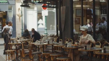 Sabahları bir kafede kahvaltı yapan genç bir kadın.