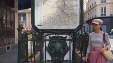 Paris metro istasyonunda telefonu olan genç bir kız.