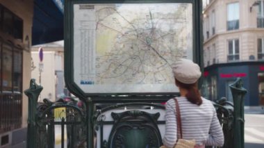 Paris, Fransa 'da haritada telefonu olan genç bir turist.