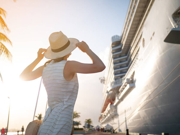 Молодая женщина на фоне белого корабля в порту
