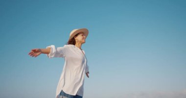 Mavi gökyüzünün arka planında mutlu bir genç kız