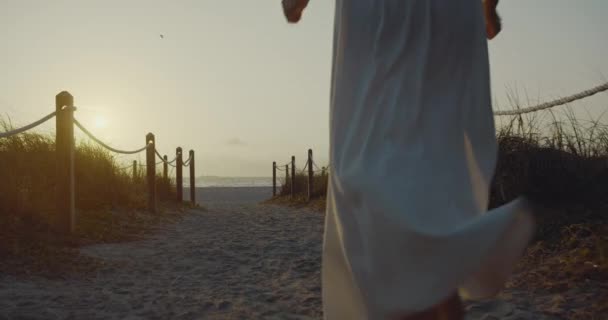 若い女の子は日の出にビーチに走っている ブラックマジックシネマカメラで撮影 — ストック動画