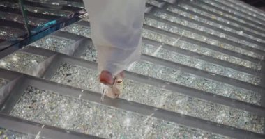 Yüksek topuklu güzel bir kadın ışıl ışıl merdivenlerde. Siyah Sihirli Sinema Kamerasında Çekim