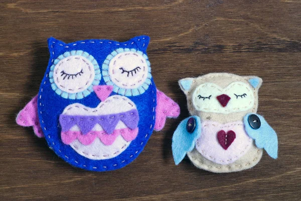 Ahşap arka plan üzerinde keçe baykuşlar birkaç