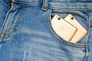 Eski kot pantolon cebinde modern akıllı telefonlar.