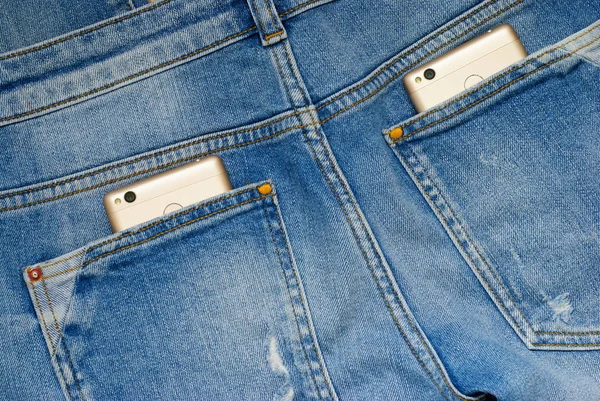 Smartphone moderni nelle vecchie tasche dei jeans . — Foto Stock