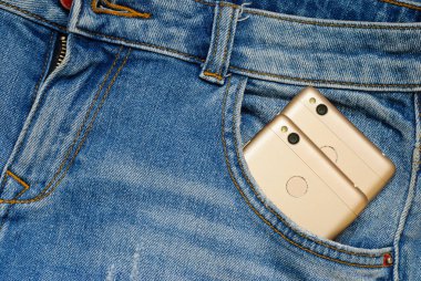 Eski kot pantolon cebinde modern akıllı telefonlar.