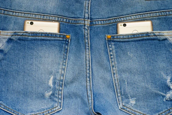 Smartphone moderni nelle vecchie tasche dei jeans . — Foto Stock