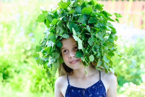 Mooi meisje met een krans van groene bladeren — Stockfoto