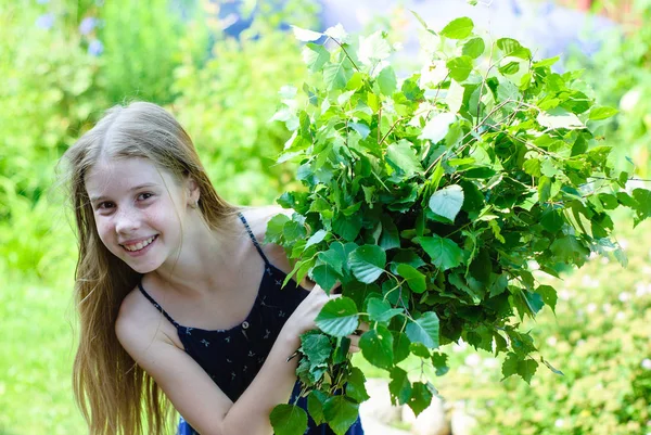 Menina bonita com um buquê de folhas verdes — Fotografia de Stock