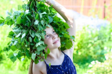 Güzel küçük bir kız ile bir çelenk yeşil yaprak