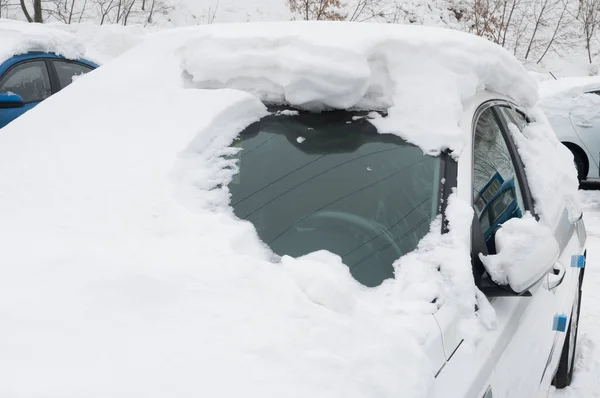 Schneeverwehungen bei schwarzem weißen Auto — Stockfoto