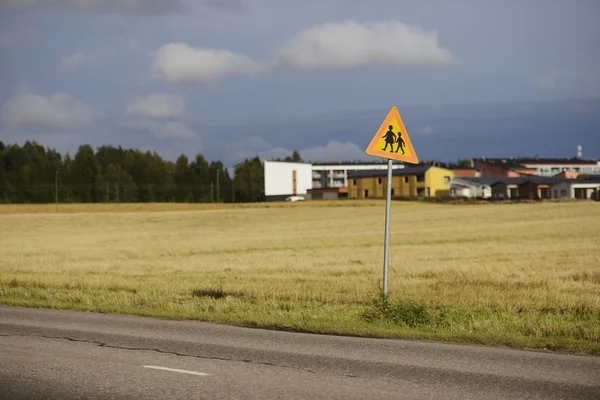 Road sign caution children against the town — Stock Photo, Image