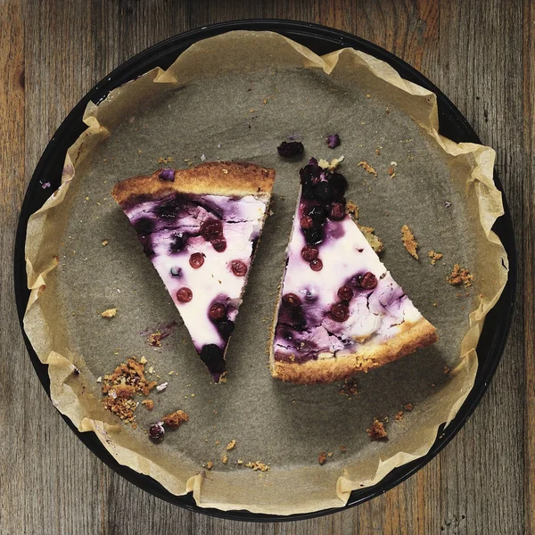 Two slices of cottage cheese cake with blueberries on paper for — Stock Photo, Image