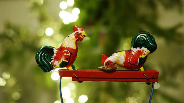 Dos pollos picotean grano de un plato, juguete de metal —  Fotos de Stock