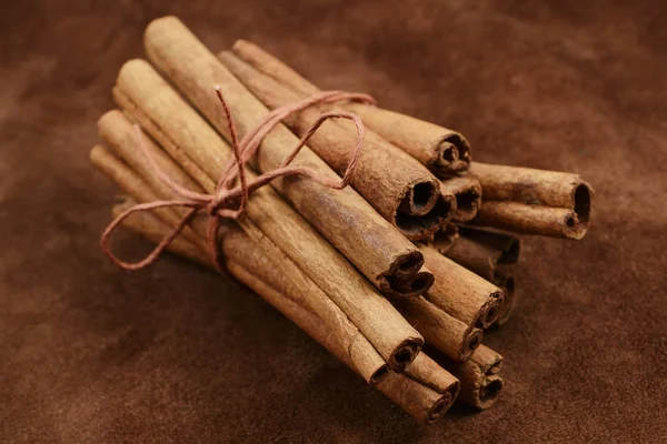 Un montón de palitos de canela sobre fondo marrón —  Fotos de Stock