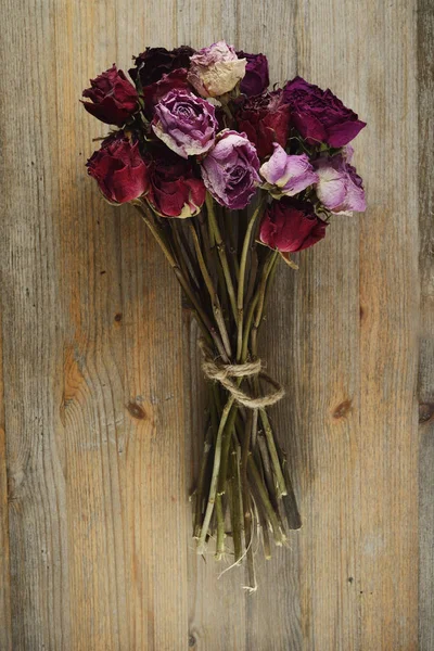 Μπουκέτο από αποξηραμένα τριαντάφυλλα σε φόντο ξύλινη — Φωτογραφία Αρχείου