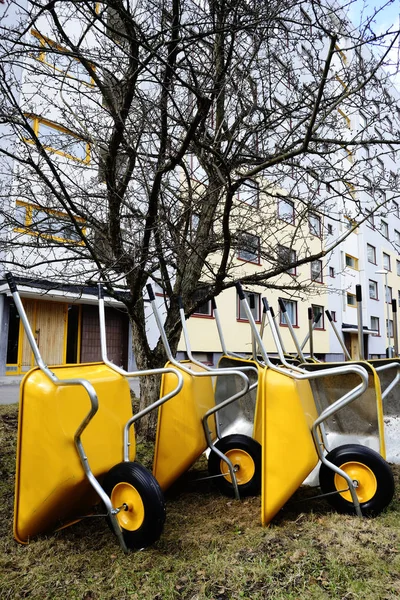 Lote de novos carrinhos de mão vazios jardim amarelo — Fotografia de Stock