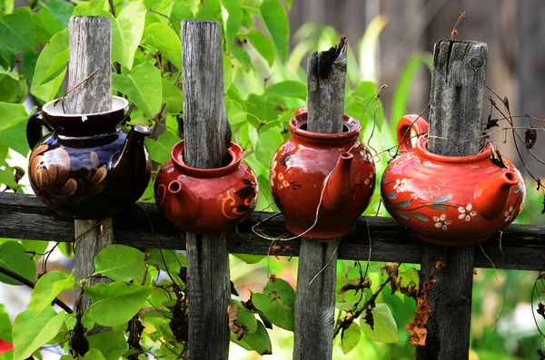 Vier Keramik-Teekannen auf einem Holzzaun — Stockfoto