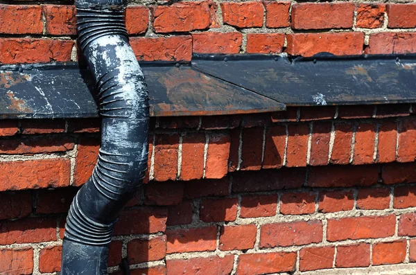 Old drainpipe on a brick wall — Stock Photo, Image