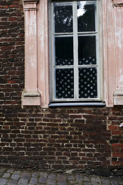 Tuğla duvar ve penceredeki Amerikan bayrağı — Stok fotoğraf
