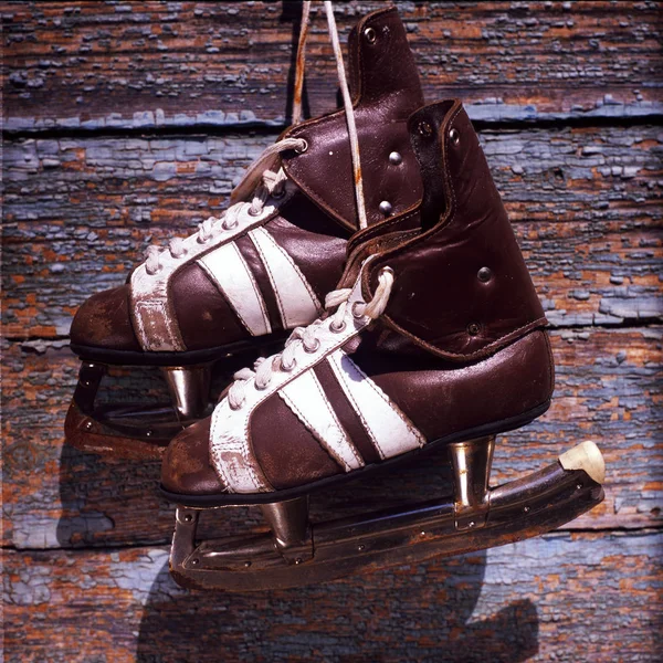 Vintage pair of mens  ice skates hanging on a wooden wall — Stock Photo, Image