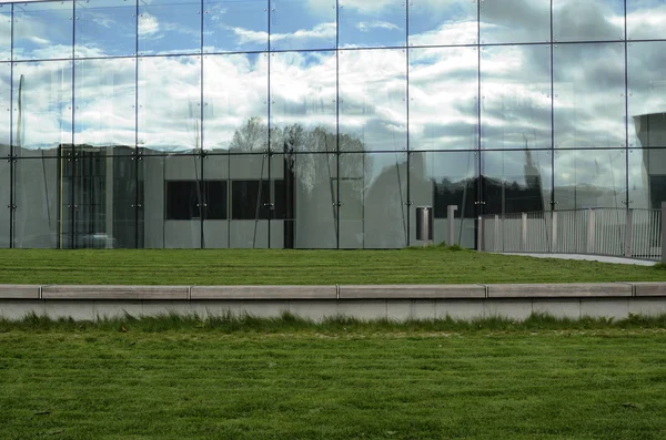 Зеленый газон и стеклянный фасад современного здания — стоковое фото