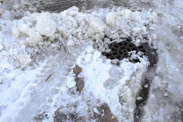Studnia kanalizacyjna burza pokryte śniegiem i lodem — Zdjęcie stockowe