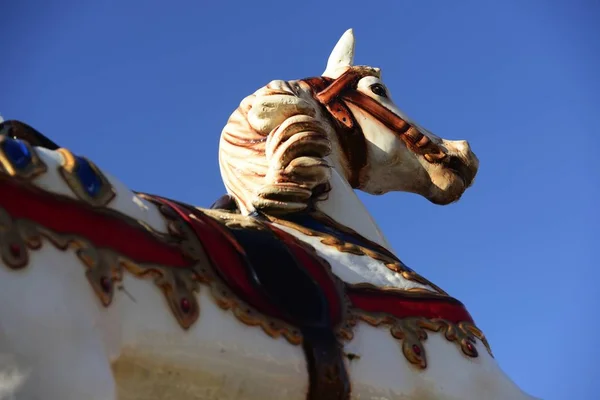 Carrusel caballo en un parque de atracciones en un cielo azul — Foto de Stock