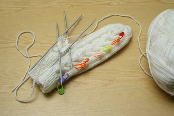 Mitenes brancas e agulhas de tricô, bola de lã — Fotografia de Stock