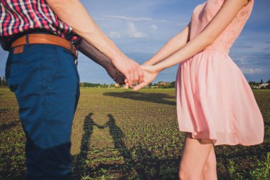 genç bir çift el ele tutuşarak sonbahar parkta yürürken sevdiğini