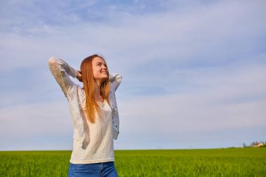 Sabah şafak arka plan üzerinde beyaz sundress kırmızı kıvırcık saçlı bir kadın
