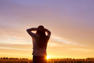 Günbatımı keyfi bir kız silüeti