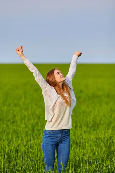 A woman with red curly hair in white sundress on background of dawn in morning — Stock Photo, Image