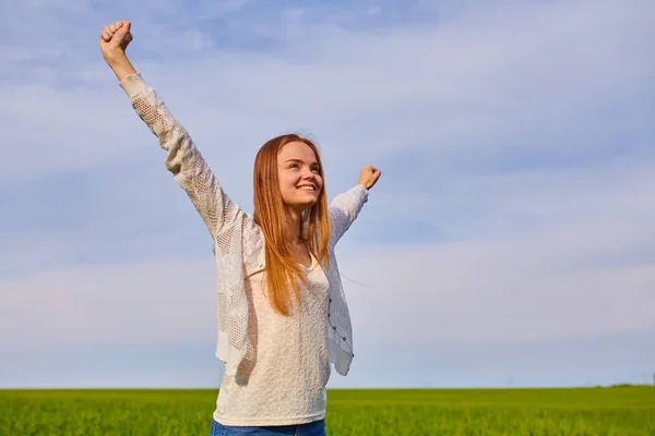 Girl with open arms on a green wheat field — Stock Photo, Image