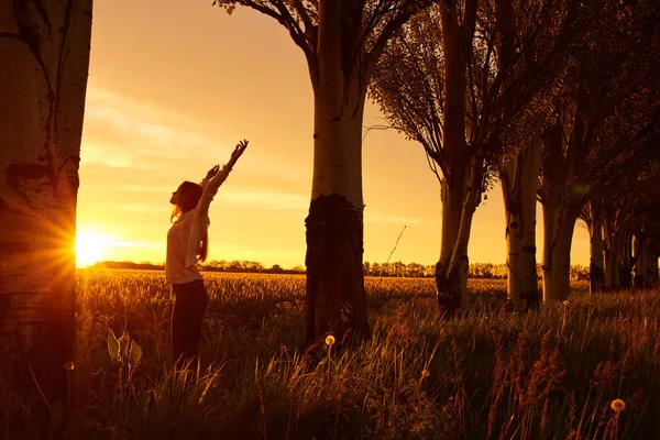Flicka med öppna armar på en grön vetefält — Stockfoto