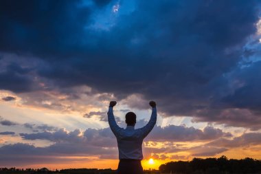mutlu işadamı, alanın üzerine Rüzgar arka plan ayakta onun elini kaldır ve thumbs up