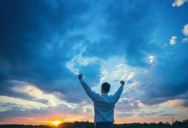 mutlu işadamı, alanın üzerine Rüzgar arka plan ayakta onun elini kaldır ve thumbs up