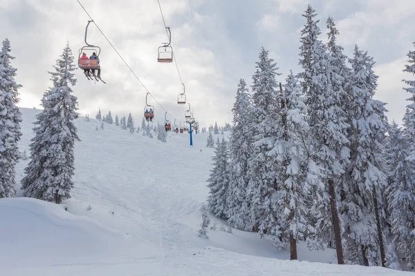 Лыжный подъемник с сиденьями, идущими над горой и тропами с неба — стоковое фото