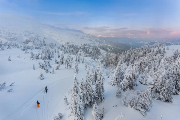 Ζευγάρι σκι σε μια περιποιημένη καμπύλο διπλό σκι track με κορυφές βουνών — Φωτογραφία Αρχείου
