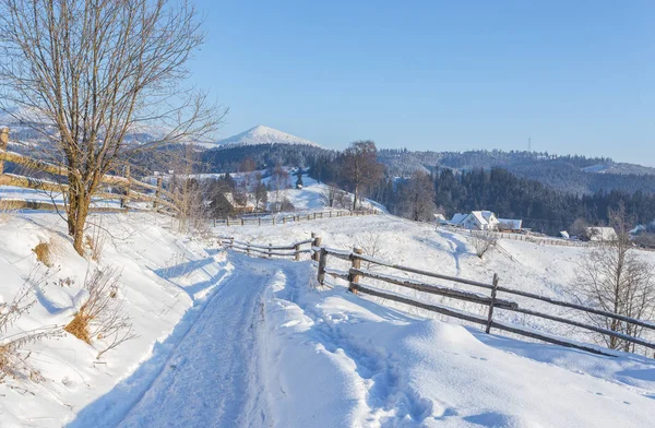 Winter landschappen met hout hek en besneeuwde weg — Stockfoto