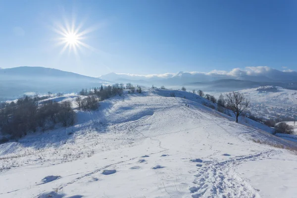 Fantastická zimní krajiny a prošlapaná turistické cesty vedoucí do pohoří. V předvečer svátku. — Stock fotografie