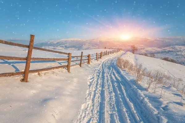 Winter landschappen met hout hek en besneeuwde weg — Stockfoto