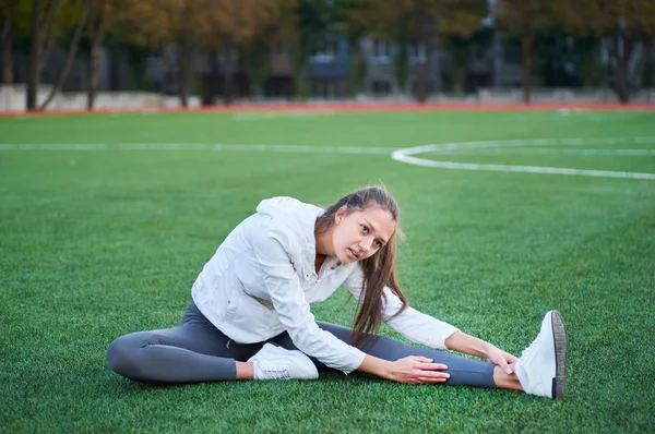 Mujer atlética estirando su pierna — Foto de Stock