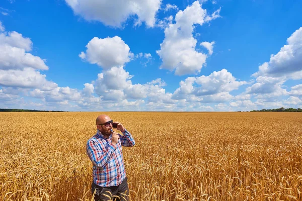 Agricultor fuma cigarrillo electrónico y llamar en un campo maduro de w — Foto de Stock