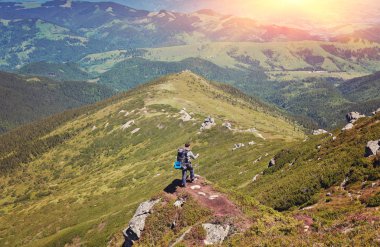 Bir uçurum kenarında duran uzun yürüyüşe çıkan kimse. Dağın tepesinde.