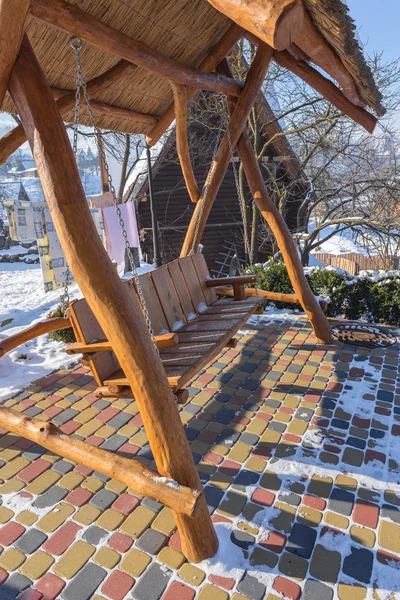 Besneeuwde schommel op de patio in de tuin — Stockfoto