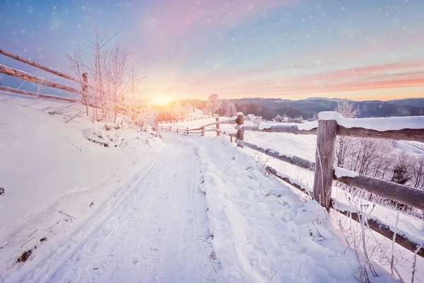 Paysage rural hivernal avec clôture en bois et route enneigée — Photo