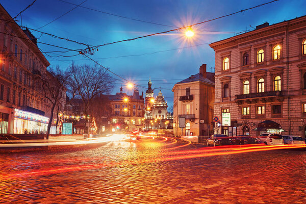 Evening street with benches and lanterns.